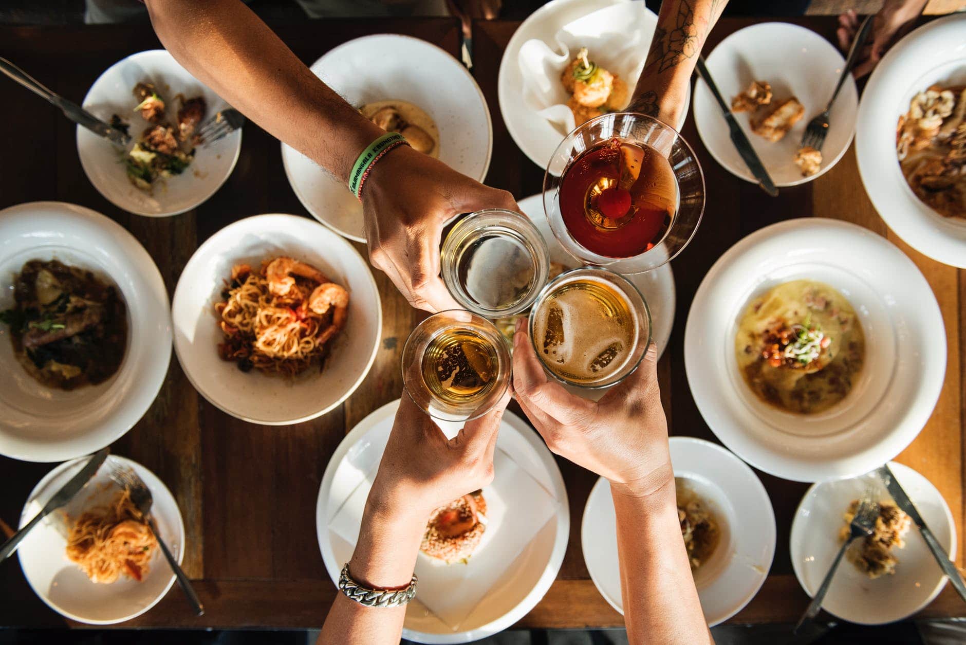 Glasses clinking over a range of appetizers